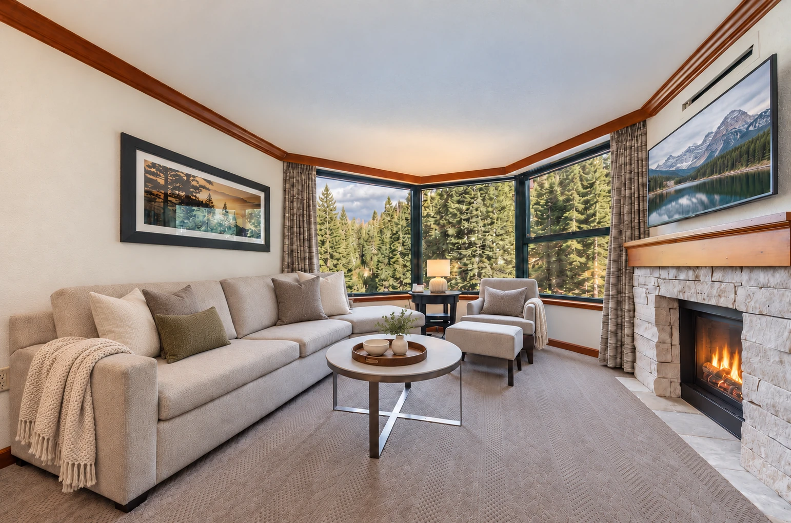 Private one-bedroom suite living room with a stone fireplace and forest windows; digitally styled linens and accessories